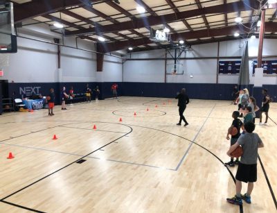 Basketball players practicing on a court.